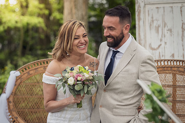 Photo de mariés assis qui tiennent le bouquet de la marié