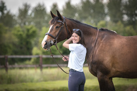 Cavalière et son cheval avec une forêt en fond