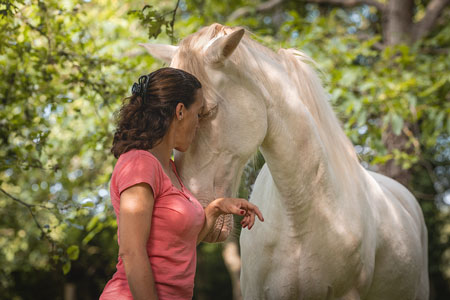 Propriétaire qui fais un câlin à son cheval les yeux fermés