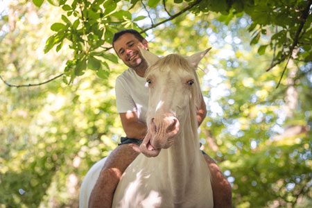 Le propriétaire est assis à cru sur son cheval qui fait la grimace