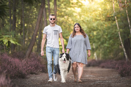 Couple et leur chien de race laika de yakouti se promenant en forêt