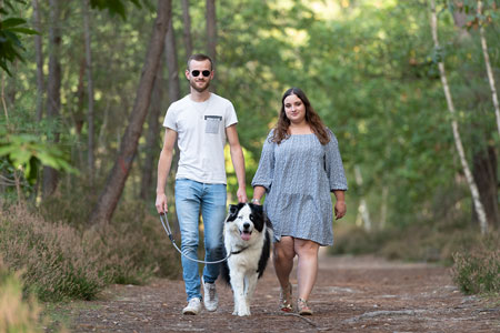 Couple et leur chien de race laika de yakouti se promenant en forêt non retouchée