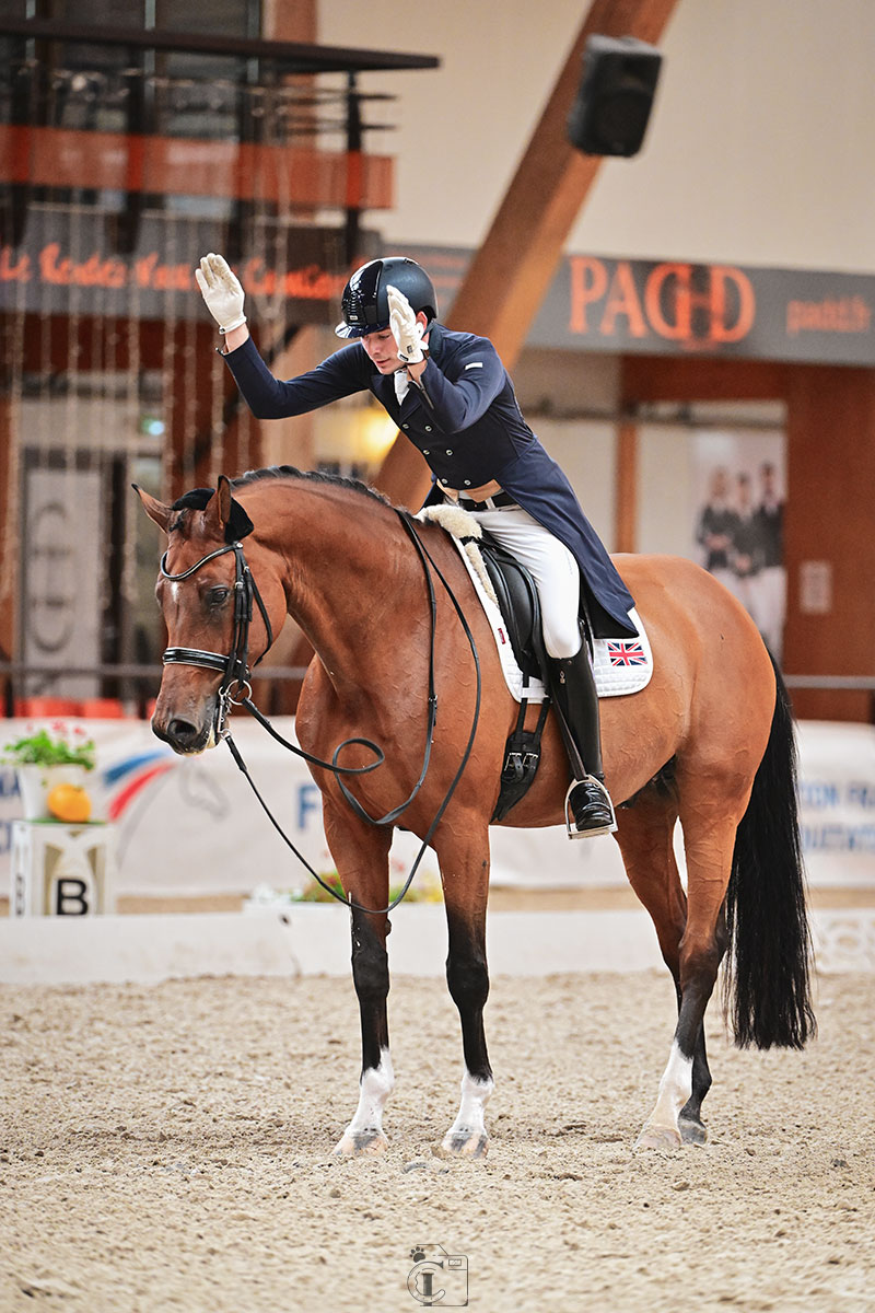 Cavalière anglaise saluant à la fin d'une reprise de dressage